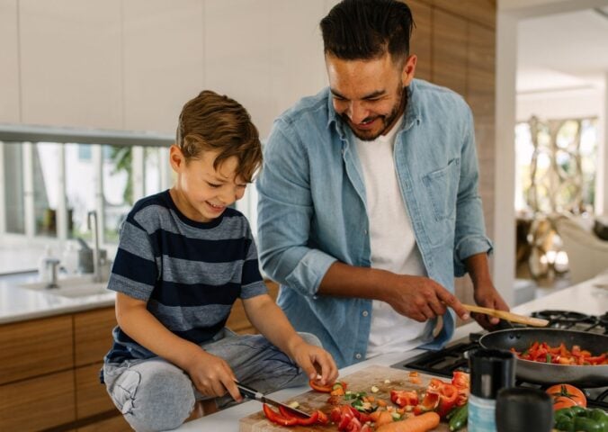 Photo shows a father and son cooking together