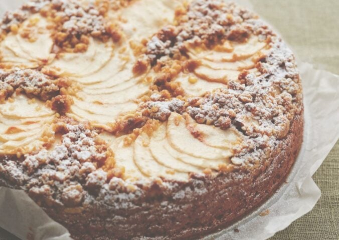 This vegan apple cake is made with cinnamon and topped with apple slices