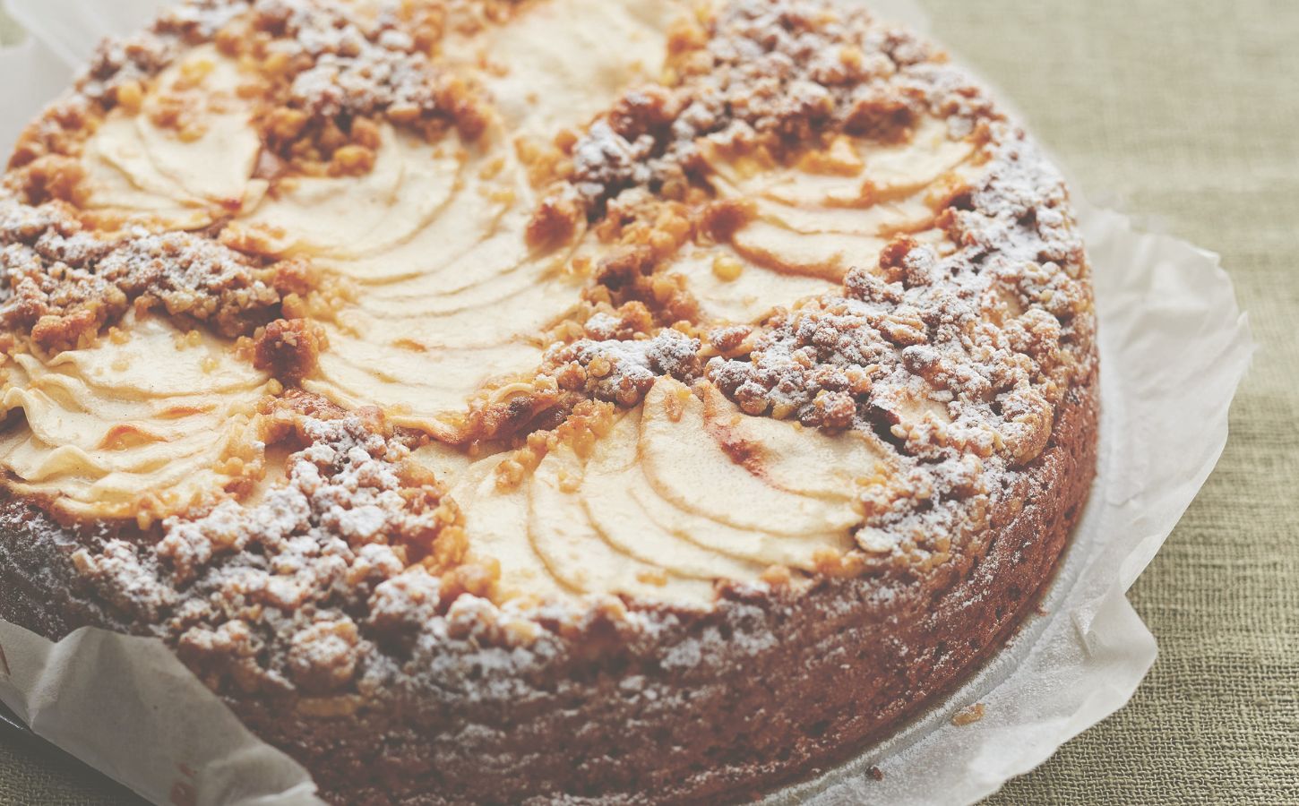 This vegan apple cake is made with cinnamon and topped with apple slices