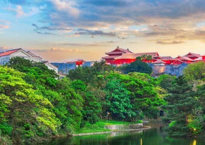 A landscape picture of Blue Zone area Okinawa, Japan, showcasing green trees and red buildings