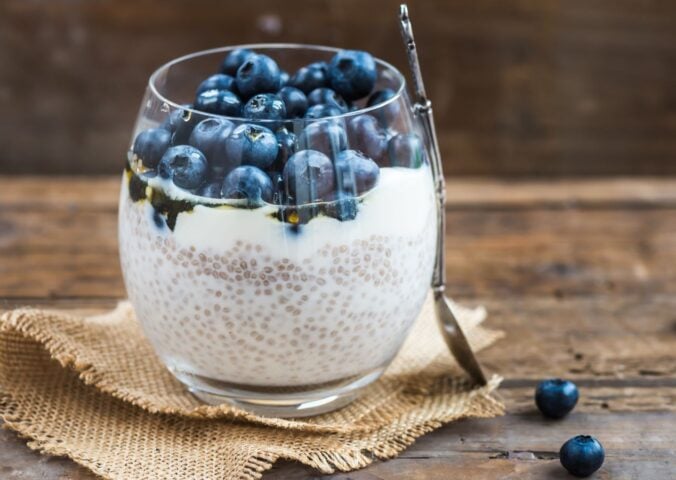 Picture shows a glass cup full of blueberry and chia seed pudding