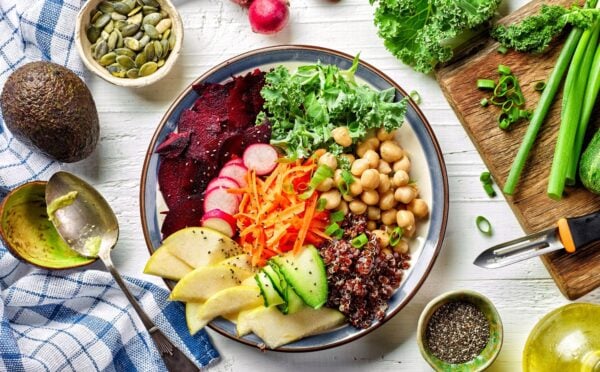 Photo shows a colorful bowl of fresh fruit, vegetables, and salad