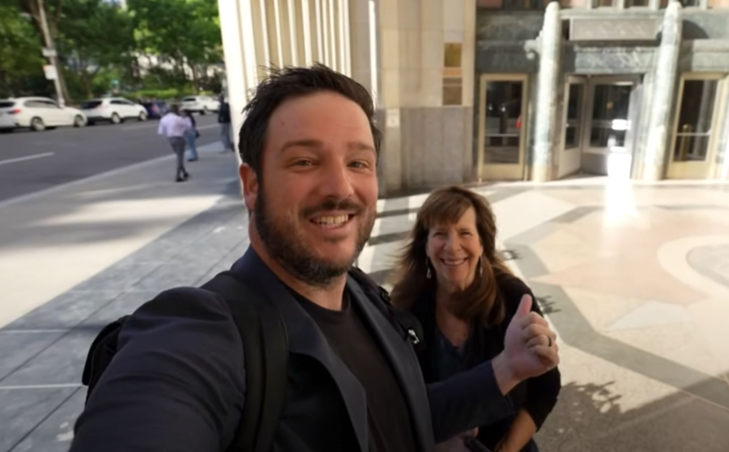 A YouTuber and his mom speaking directly to camera on the street in a video reviewing Eleven Madison Park