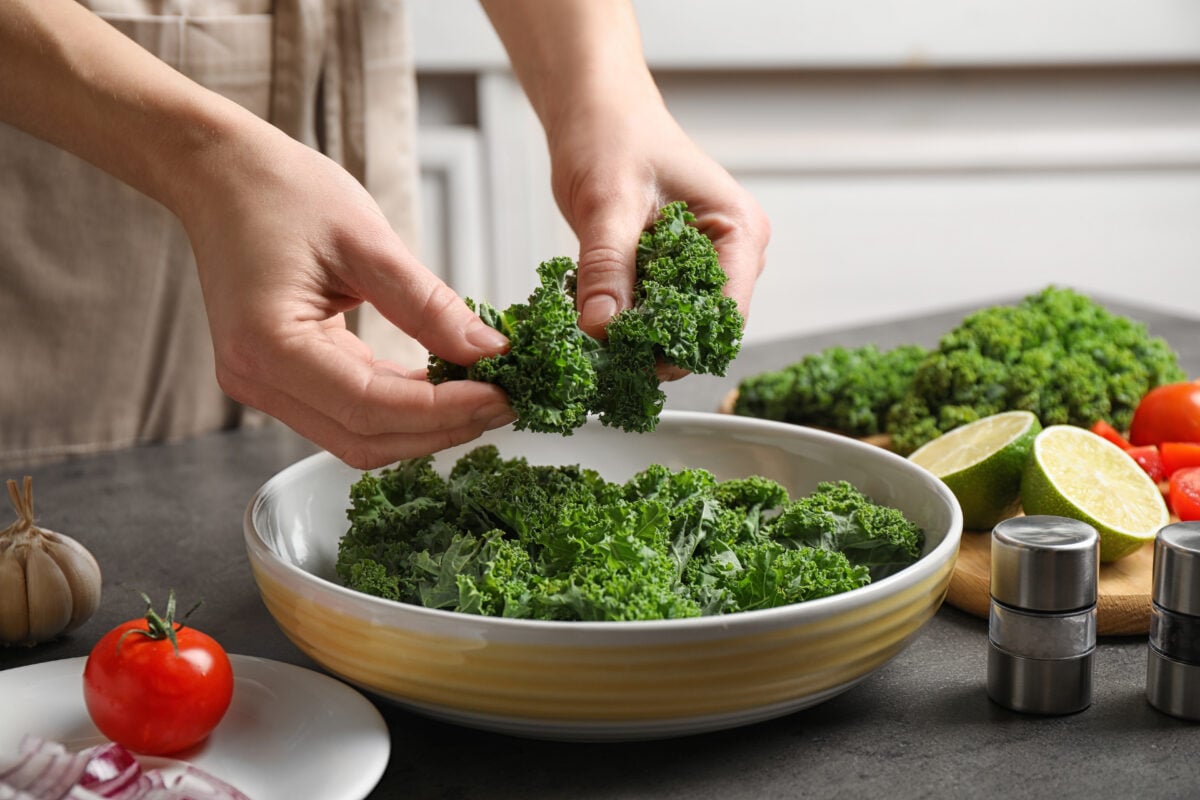 A woman preparing kale in a pot