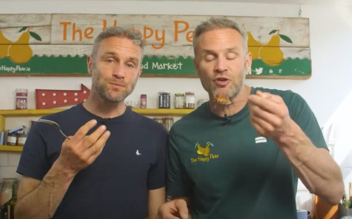 The Happy Pear twins David and Stephen Flynn eating high protein vegan lasagna in a still from a YouTube video on the recipe