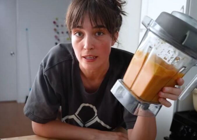 Merle O'Neal holding her romesco sauce in a blender for Tom Brady's high-protein vegan diet