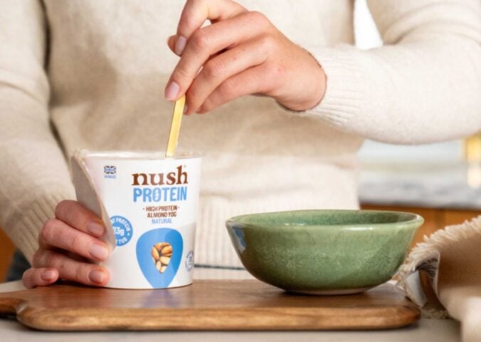 A person spooning a Nush high protein, soy-free yogurt