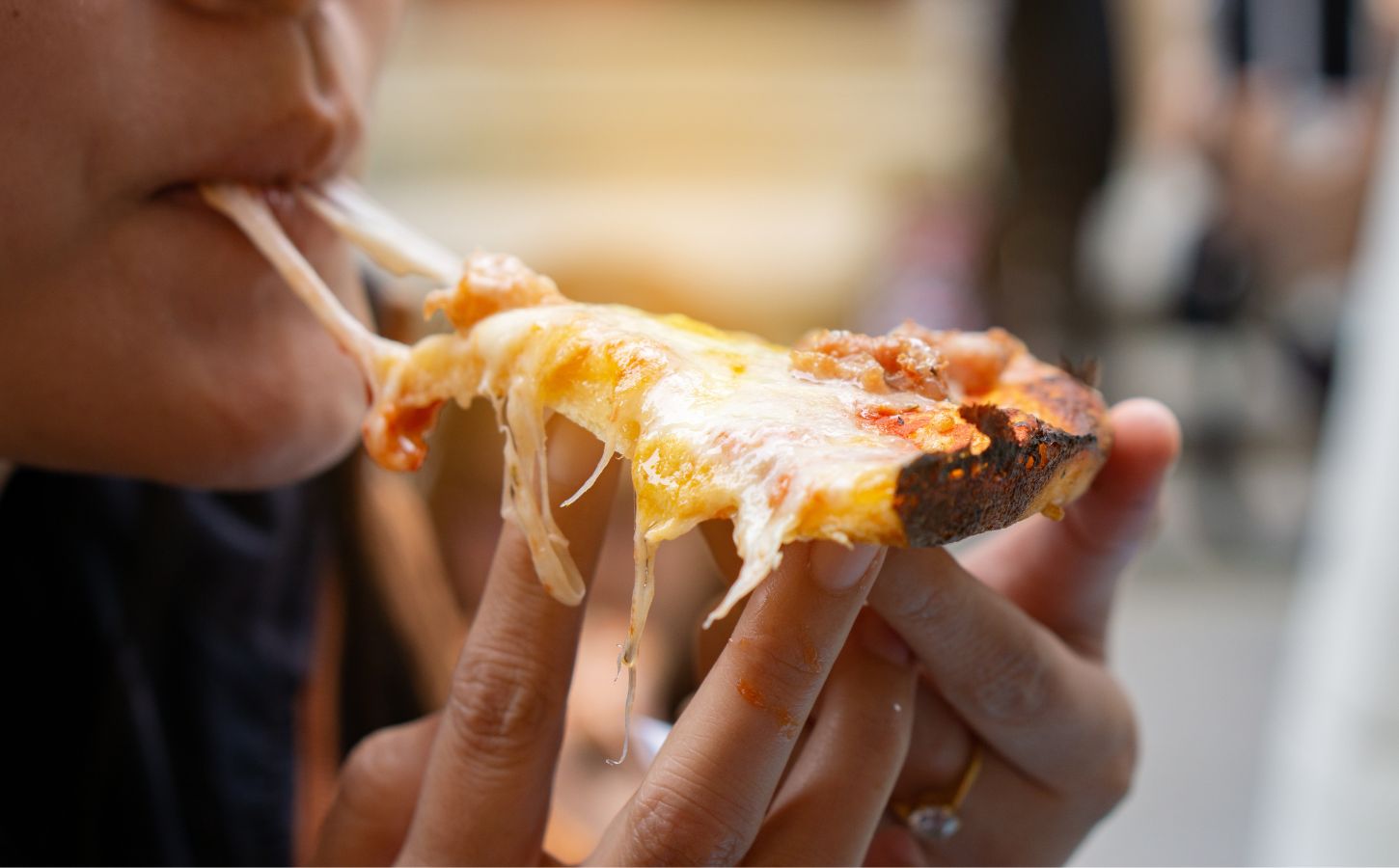 A person eating a dairy cheese pizza
