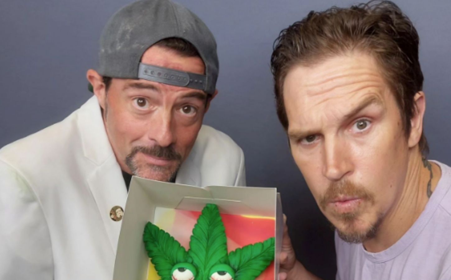Vegan celebrity Kevin Smith holding up a vegan cake