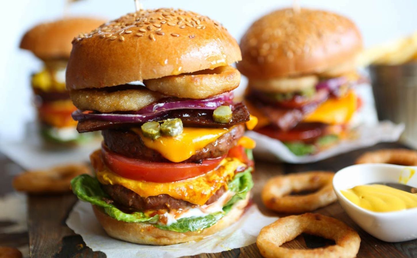 Viva Vegan Recipe Club's meat-free mega burger stacked with dairy-free cheese, salad, and onion rings