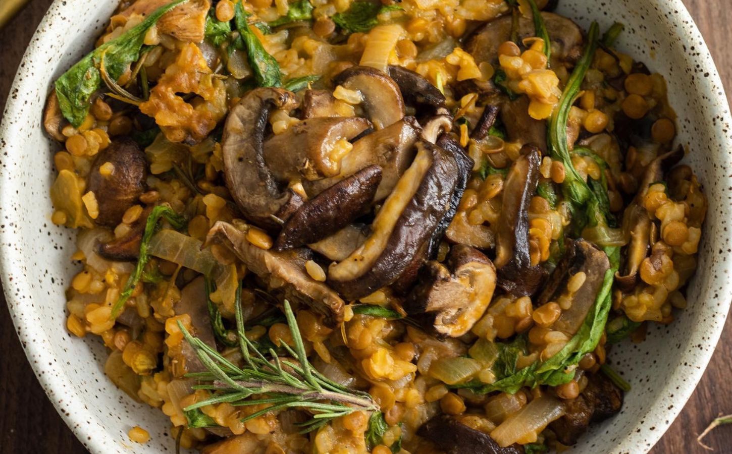 Vegan lentil and mushroom risotto served with fresh thyme sprigs, a high protein vegan dinner idea
