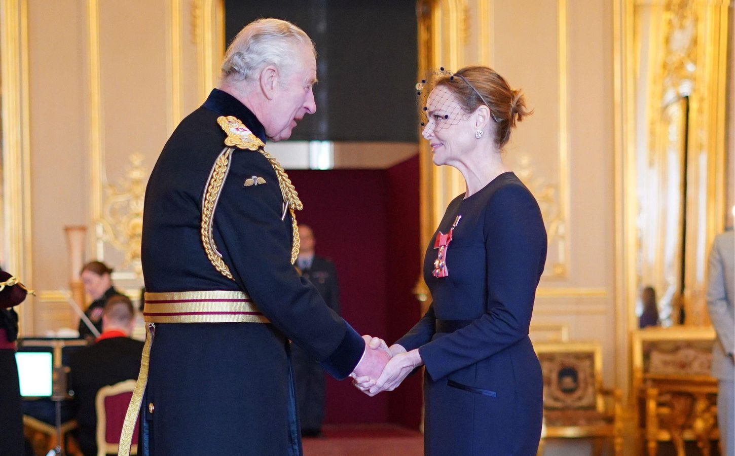 Vegetarian designer Stella McCartney shaking hands with King Charles after receiving her CBE