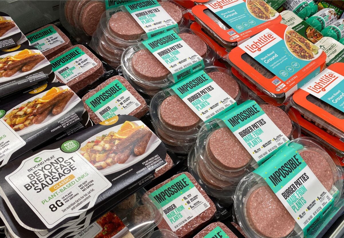 Photo shows a selection of plant-based meat products in a refrigerator, including brands like Impossible, Lightlife, and Beyond Meat