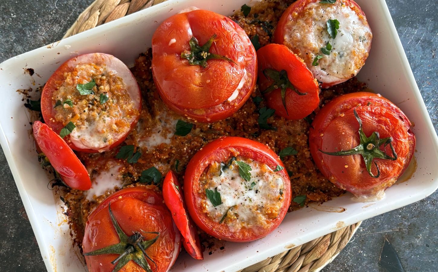 A tray of quinoa stuffed tomatoes with plant-based feta