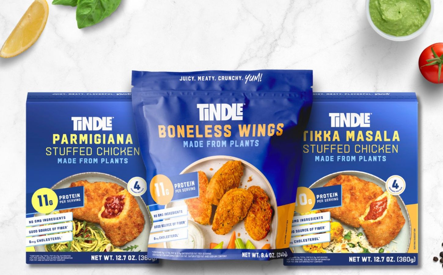 Photo shows the packaging of three core TiNDLE products: Parmigiana flavor Stuffed Chicken, Boneless Wings, and Tikka Masala Stuffed Chicken (L-R)