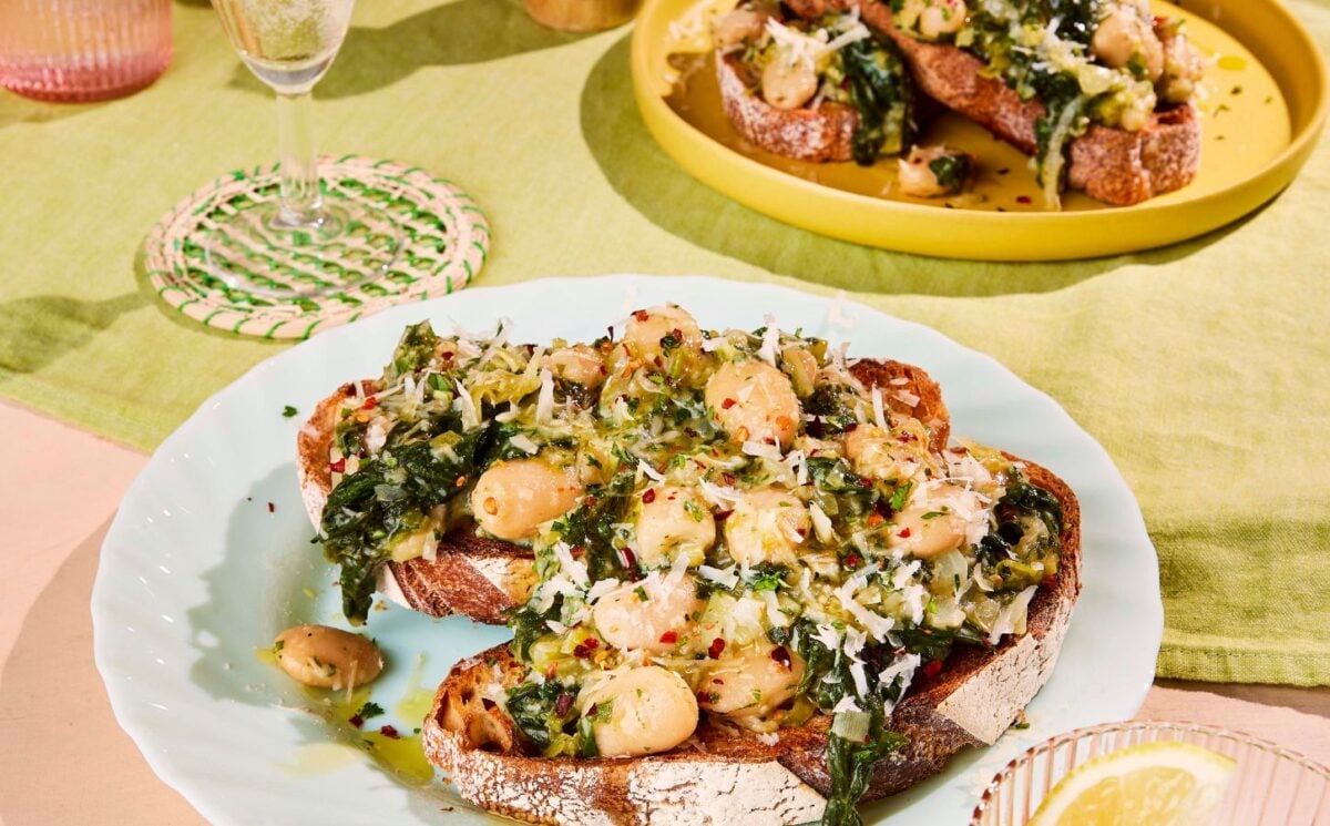 two plates of boozy butter beans and greens with spinach, mustard, and vegan parmesan for vegan brunch recipes