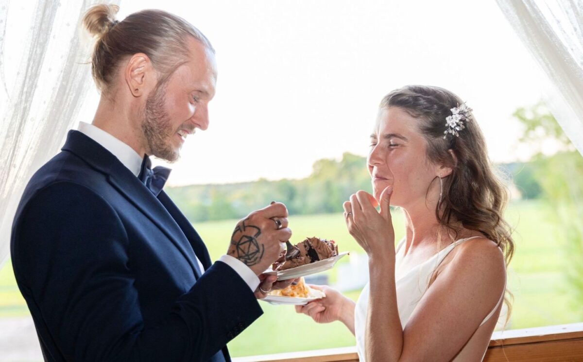 Photo shows Andrea and Marcus sharing vegan wedding cake