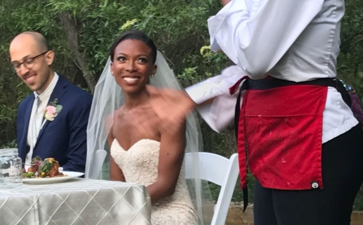 Photo shows Jenné and Maxx at their wedding alongside other guests